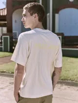 Remera color crema de manga corta y cuello redondo con estampa en la espalda con la palabra "MALIBU".