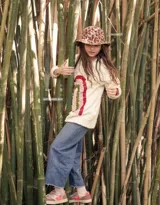 Sweater color crema de tejido de punto con cuello redondo y mangas largas. Presenta un arcoíris bordado a mano en el frente.