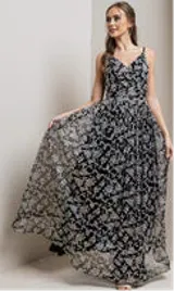 Vestido largo de fiesta negro con breteles finos y escote en V. El vestido es de tul bordado con flores y lentejuelas plateadas.