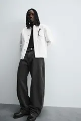 Pantalón de jean celeste con efecto lavado, corte holgado desde la cadera que se estrecha ligeramente en el bajo, tiro medio, cinco bolsillos y cierre frontal con cremallera y botón.