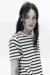 Remera de algodón color crudo con rayas horizontales negras, corte recto, cuello redondo y mangas cortas.