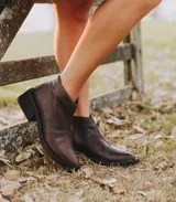 Botas cortas de cuero color marrón con cierre lateral, taco de madera de 5cm y suela de caucho.