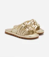 Sandalia plana de color negro con diseño de tiras tubulares acolchadas tipo puffer entrelazadas con nudos. Presenta puntera redonda, plantilla anatómica y suela de goma al tono.