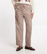 Pantalón jogger de tricolina color beige con estampado de cuadros, cintura elástica con lazo y bolsillos laterales.