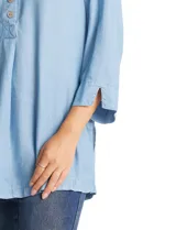 Blusa de lyocell color azul claro, con cuello camisero, escote en V y abertura frontal con tres botones. Mangas 3/4 amplias.