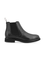 Botín Chelsea de cuero negro, con elástico lateral y tirador trasero.