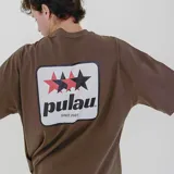 Remera color beige de corte holgado con logo de la marca Pulau bordado en el pecho.