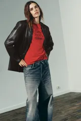 Blazer marrón oscuro de efecto piel, con cuello solapa y manga larga. Tiene bolsillos de plastrón en la parte delantera, forro interior a tono y cierre frontal con botones.