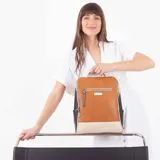Mochila combinada en tres tonos: marrón, beige y negro. Tiene un bolsillo frontal con cierre, asa de mano y correas regulables.