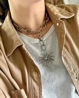 Collar plateado con cadena gruesa y dije en forma de sol.
