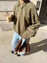 Campera bomber marrón de efecto ante, con cuello clásico, cierre frontal con cremallera y mangas largas.