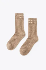 Calcetines color beige con textura acanalada y detalle de perlas sintéticas en el borde superior.