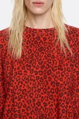 Minivestido rojo con estampado animal print en tonos marrones, de corte recto, cuello redondo y mangas cortas.