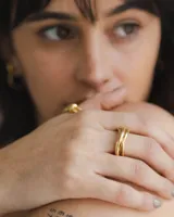 Anillo dorado con diseño de tres bandas entrelazadas.