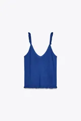 Top azul de punto con escote en pico y tirantes finos con volantes.
