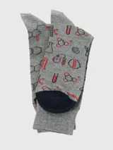 Par de calcetines largos de algodón gris jaspeado con estampados temáticos de química y laboratorio en tinta negra y roja. Cada calcetín tiene un diseño diferente.