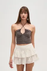 Top sin mangas marrón con estampado de ondas color crema, cuello halter y espalda descubierta.