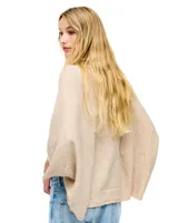 Cardigan negro de tejido suave, estilo poncho o capa, con cuello tipo chal y mangas amplias.