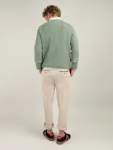 Jersey de punto inglés verde con rayas horizontales blancas, cuello redondo y logo bordado en el pecho.