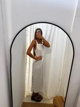 Vestido largo blanco, de corte recto, con breteles anchos y tajos laterales.