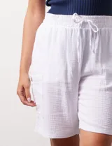 Bermuda blanca de algodón texturizado, marca Robert Louis. Tiene pretina ancha elastizada con lazo, bolsillos verticales delanteros y bolsillos laterales con botón.