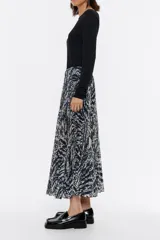 Falda plisada midi con estampado de zebra en tonos azules y blancos, con cintura elástica y abertura delantera.