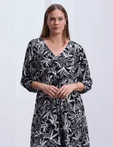 Vestido corto de rayón con estampado floral en tonos azules y blancos. Tiene escote en V, mangas 3/4 con puño, cintura con lazo de ajuste y borlas.