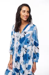 Vestido midi blanco con estampado floral en tonos de azul, corte evasé, mangas 3/4 y cuello en V.