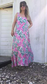 Vestido largo con estampado de hojas en tonos rosa, verde y blanco. Tiene breteles finos y corte amplio con volado en el ruedo.
