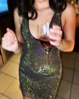Vestido corto de fiesta con escote en V, confeccionado en tela de strass tornasolado y forro interior de tul alicrado a tono.