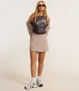 Short pollera color beige con superficie texturizada efecto lino y traspase delantero. De corte sastrero.