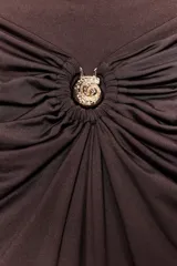 Falda midi marrón chocolate de tiro alto, confeccionada en poliamida con cintura elástica, detalle de frunces y caracola metálica dorada en el delantero.