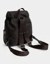 Mochila de tela color lila, con solapa con broche y tira de ajuste, doble bolsillo frontal con broche y pouch con charm lateral en forma de cartera.