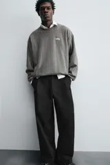 Sudadera gris con rayas verticales blancas, cuello redondo, manga larga y bordado con texto en el pecho.