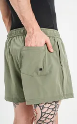 Short de baño verde militar de calce regular, con elástico en la cintura, cordón de ajuste con inscripción "LUXURY" y tres bolsillos.