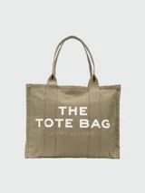 Bolso tote Marc Jacobs color beige con estampado frontal del logo "The Tote Bag" en blanco y el nombre de la marca en marrón claro.