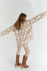 Sweater de lana color beige con diseño geométrico de rombos en tonos beige y blanco, cuello en V y corte holgado.