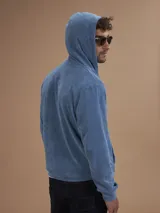 Campera con capucha de toalla de algodón color verde azulado, con cierre frontal y bolsillos laterales.