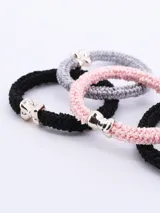 Pack de cuatro coleros para el pelo, de colores negro, gris y rosa, con adorno metálico plateado en forma de moño.