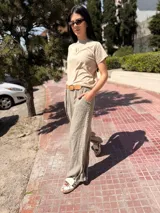Pantalón de lino color gris con bordado lateral y bolsillos.