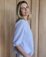 Remera blanca de algodón con mangas 3/4 abullonadas y cuello redondo. Presenta costuras a contratono en ruedo y cuello.