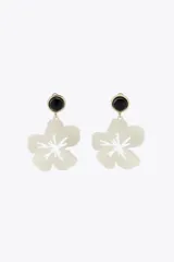 Aros colgantes con forma de flor color crema y botón negro en la parte superior.