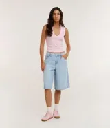 Blusa básica sin mangas color blanco, confeccionada en algodón con elastano, con escote en V y textura acanalada.