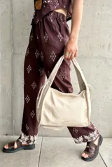 Pantalón marrón con estampado de rombos blancos y cintura elastizada.