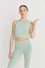 Top deportivo color verde agua, de cintura ancha con compresión suave, recortes en el delantero y tejido doble y ligero.