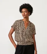 Blusa de crepé color beige con estampado de leopardo, escote en V, manga corta y bajo elástico.