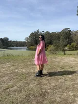 Vestido corto rosa de fibrana, corte oversize, con cuello camisero, mangas cortas y bolsillos laterales.