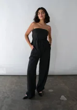 Mono strapless negro con corte en A y lazo en la cintura.
