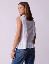 Blusa blanca texturizada de la marca Marissa Olivia. Presenta apliques de crochet en la parte delantera y un detalle fruncido en el ruedo.