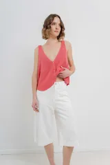 Bermuda de tiro medio color crema, con corte recto y largo a la rodilla. Diseño amplio tipo culotte corto, con dobladillo ancho en el ruedo. Presenta bolsillos delanteros y traseros funcionales.